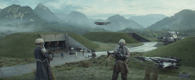 Two armored figures standing in a scenic mountainous landscape, with a futuristic base and spacecraft in the background.
